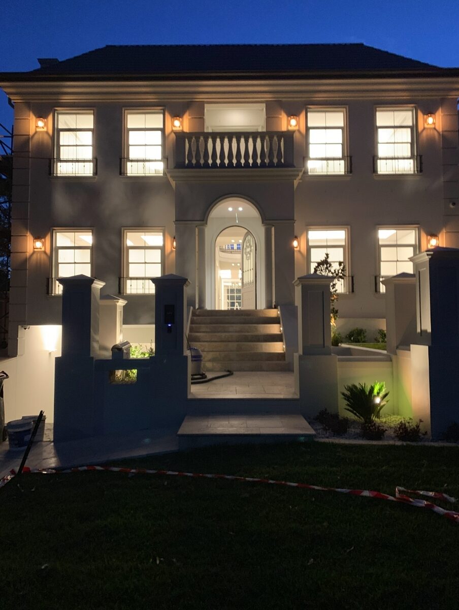 Home facade with exterior wall lights at dusk